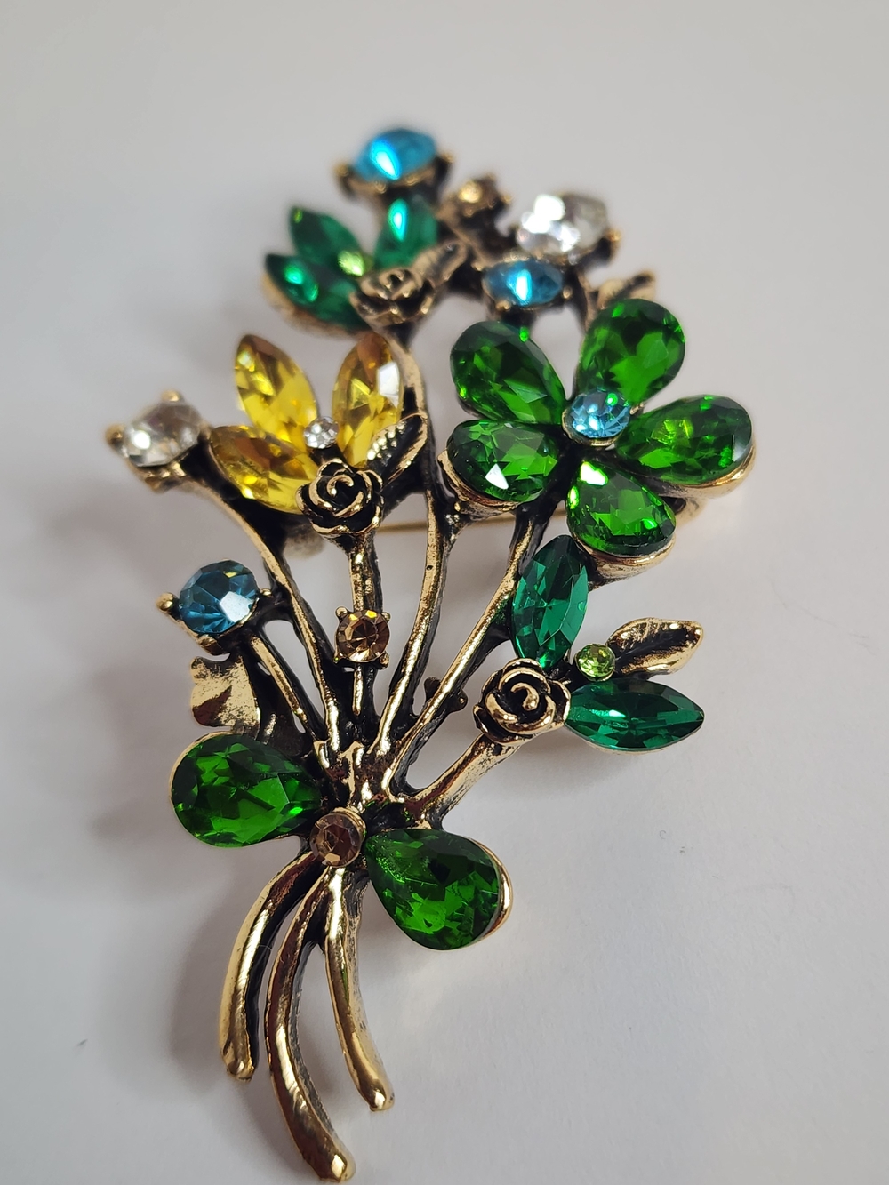 Green Floral Brooch with Blue and Yellow accents.  Gold Tone.  NWOT. 2.75 x 1.5"